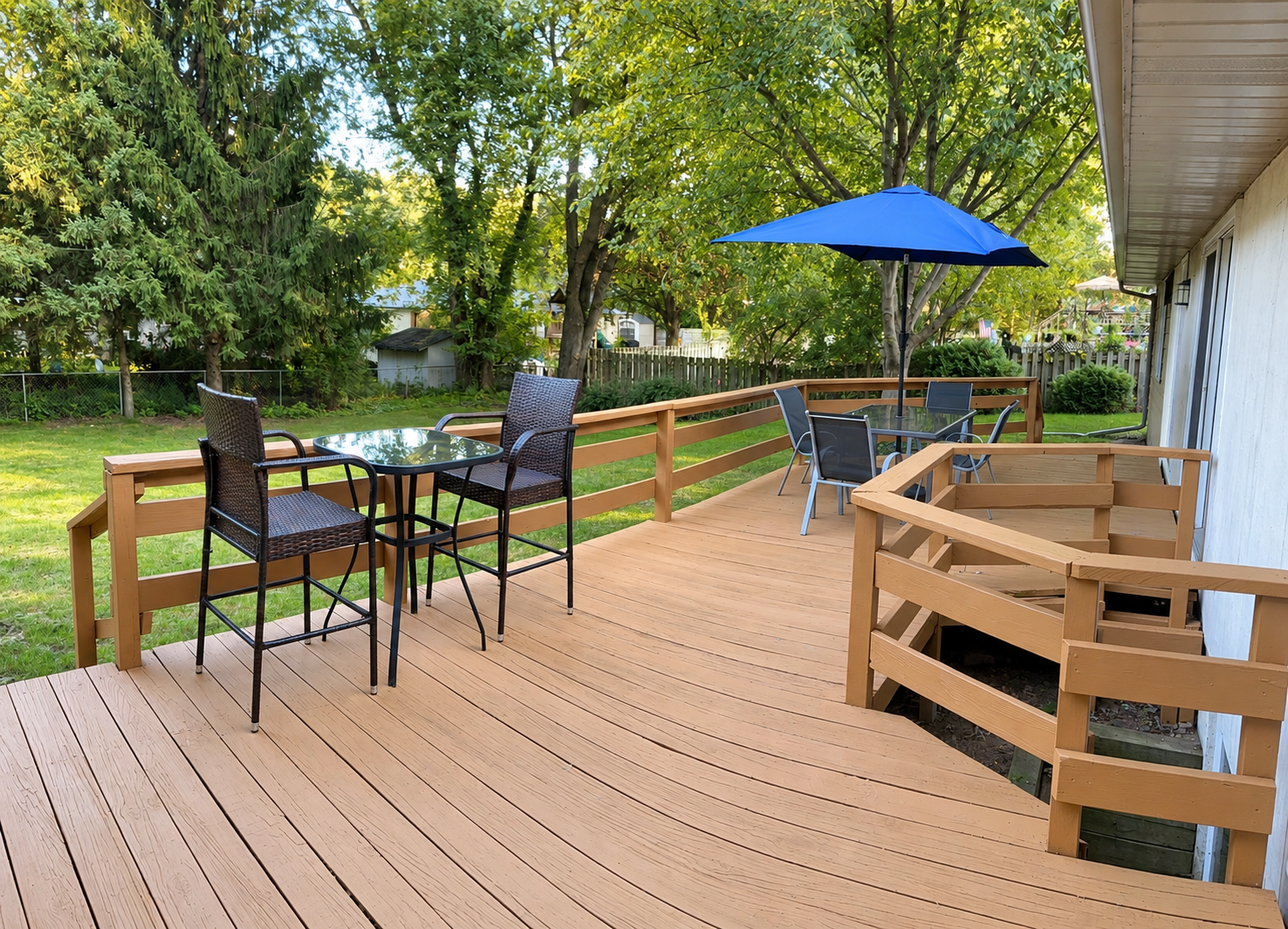 Back deck with outdoor seating and a blue umbrella